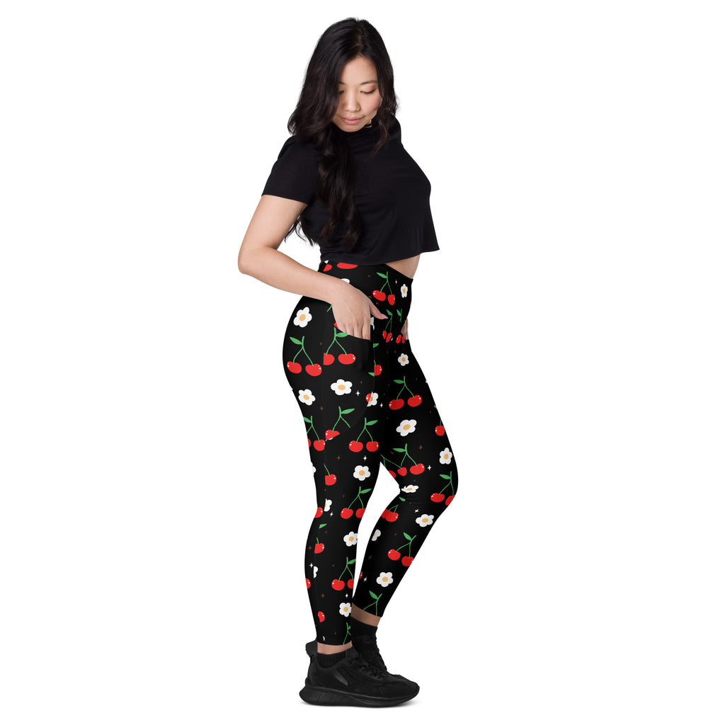 Black high-waisted yoga leggings with pockets featuring a playful red cherry and white flower print with soft compression
