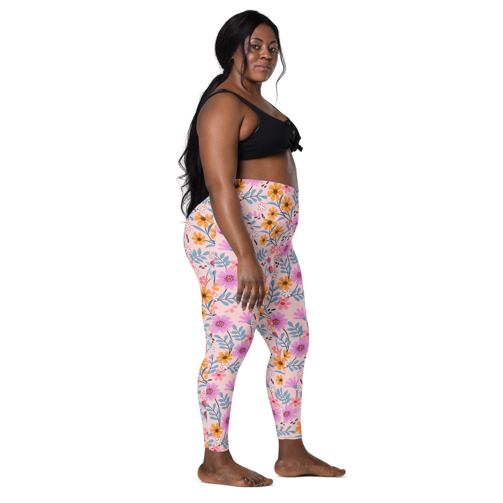 Women’s pink floral yoga leggings with pockets featuring orange and purple flowers on a soft high-waisted fabric