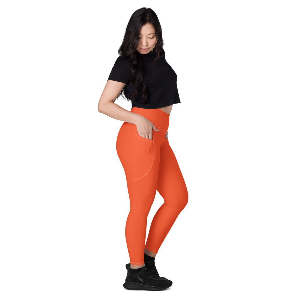 Women’s bright orange high-waisted yoga leggings with soft compression fabric and convenient side pockets