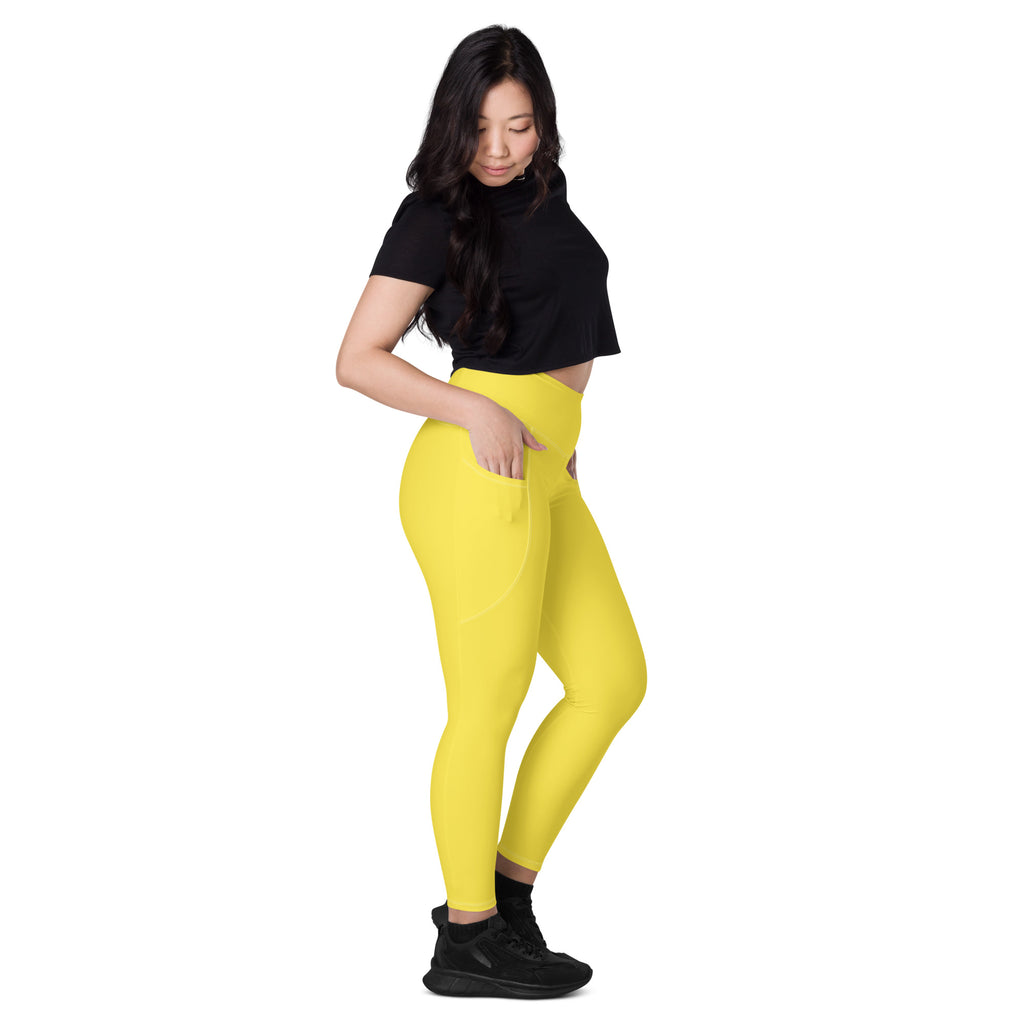 Women’s bright yellow high-waisted yoga leggings with pockets and soft compression fabric in a sleek form-fitting design