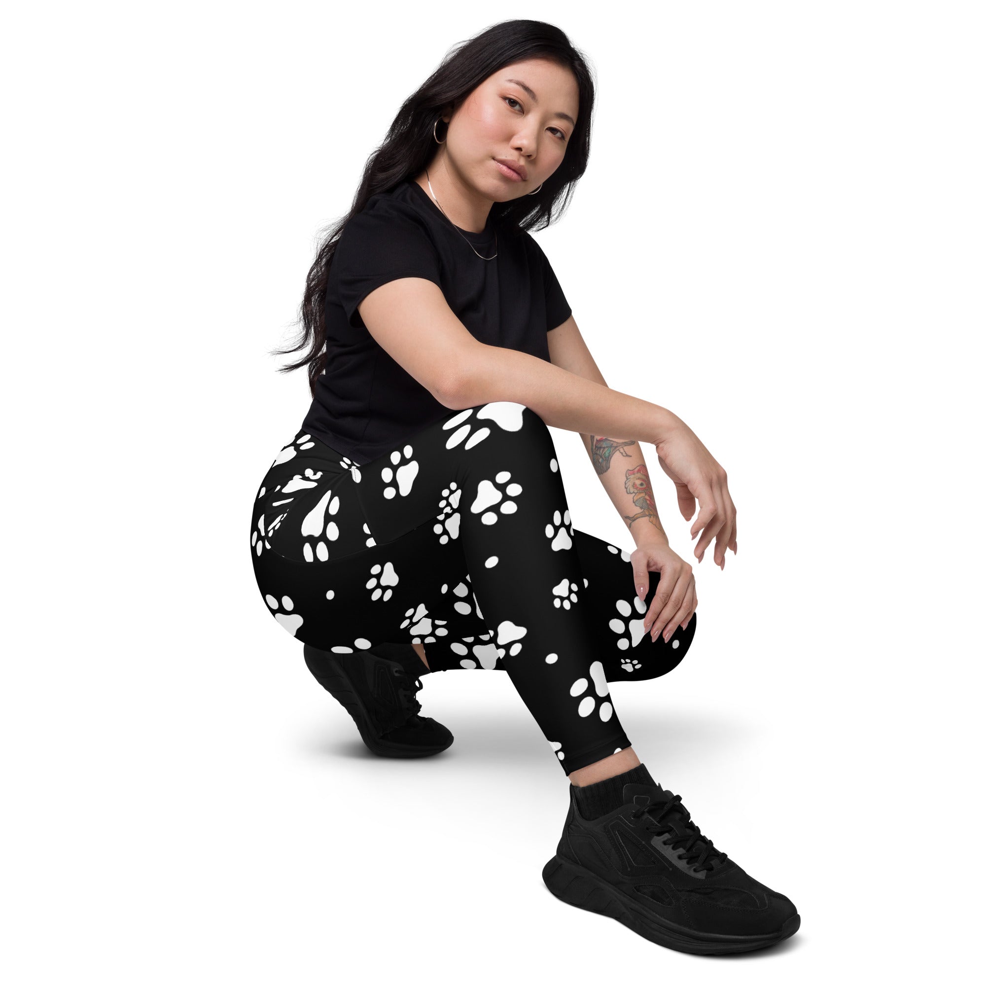 Black women’s high waisted yoga leggings with soft compression featuring white paw print pattern and pockets