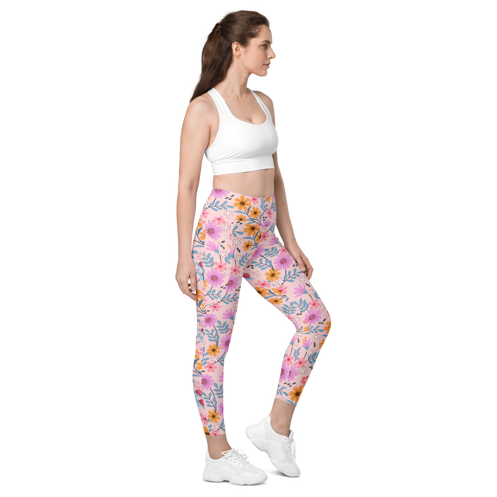 Women’s pink floral yoga leggings with pockets high-waisted soft compression fabric and orange and blue accents