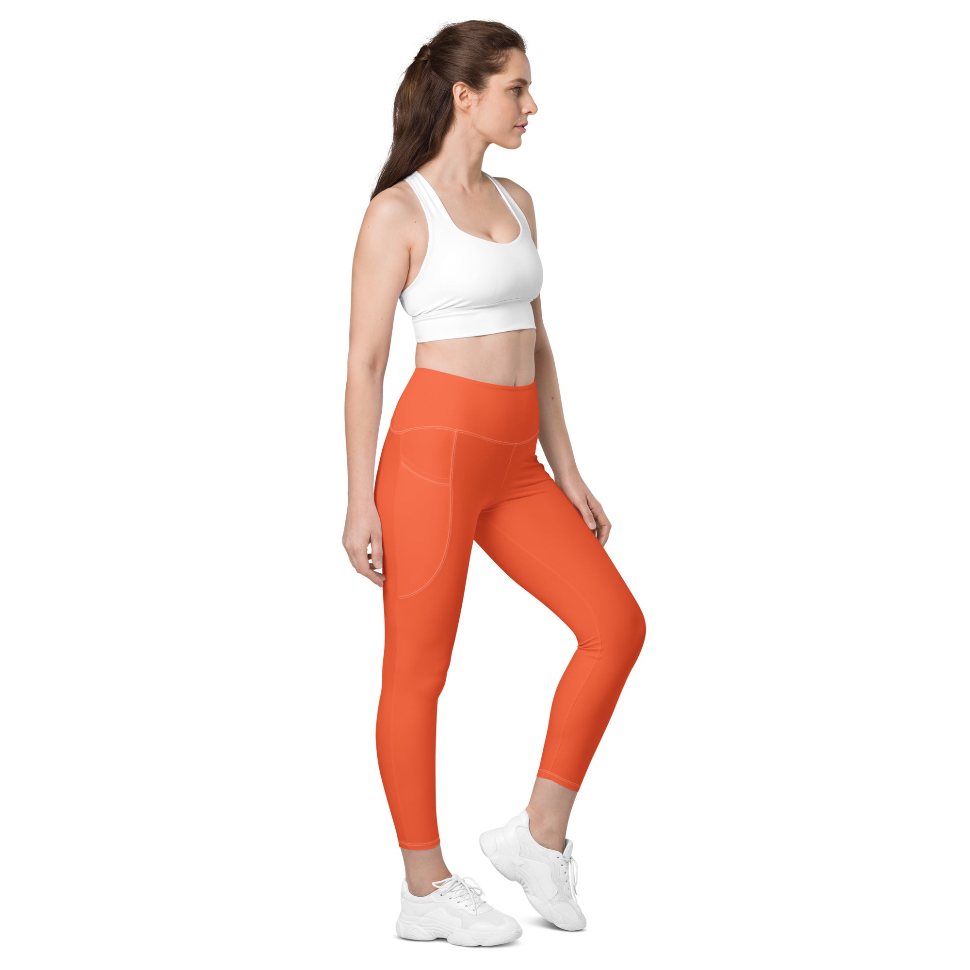 Women’s orange high-waisted yoga leggings with soft compression, pockets, and subtle side seam detailing
