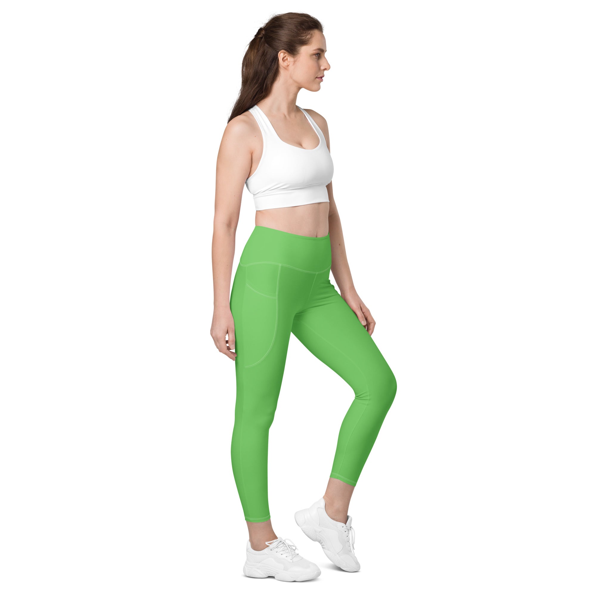 Women’s green high-waisted yoga leggings with pockets made of smooth, soft compression material and subtle side seams