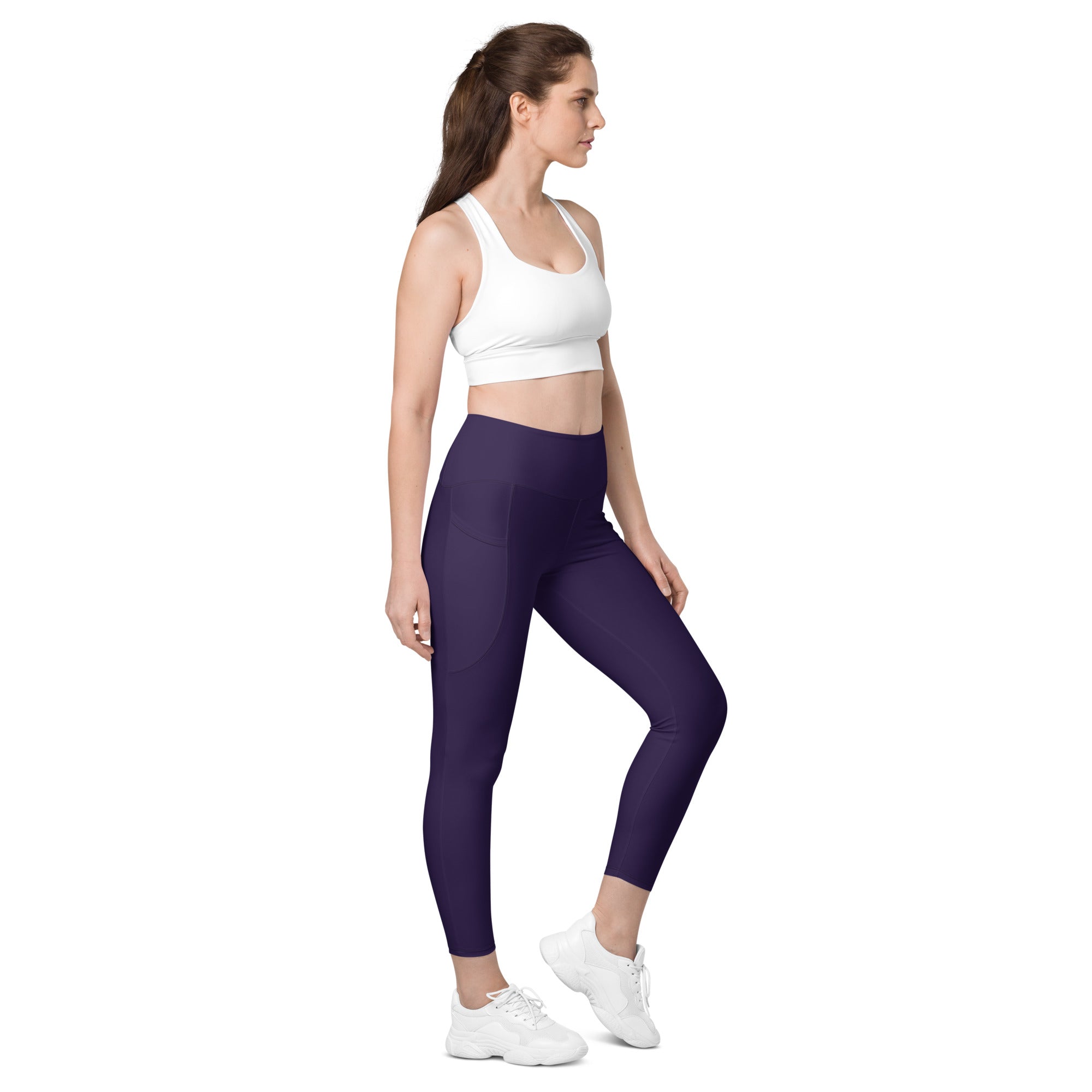 A pair of deep purple high-waisted yoga leggings with pockets made of smooth stretchy soft compression fabric
