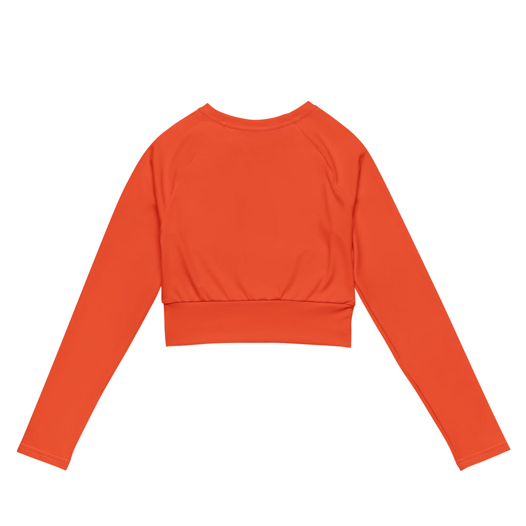 Women’s orange long sleeve performance crop top with vibrant color, fitted ribbed waistband, and smooth fabric