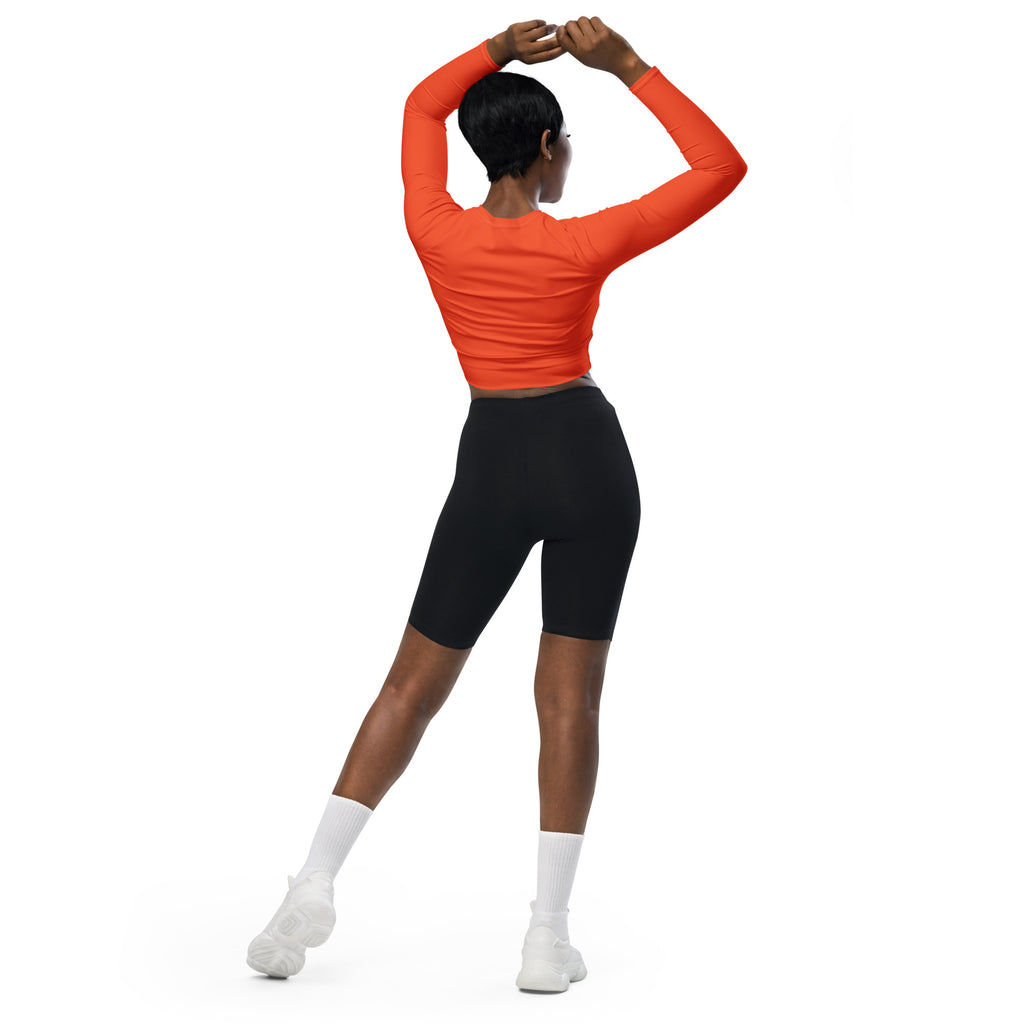 Women’s orange long sleeve performance crop top with fitted ribbed texture and high neckline