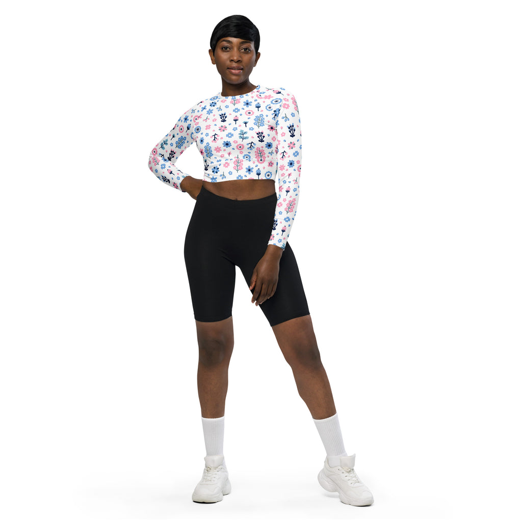 White long-sleeved crop top with pastel floral print in pink blue and green performance fabric for women