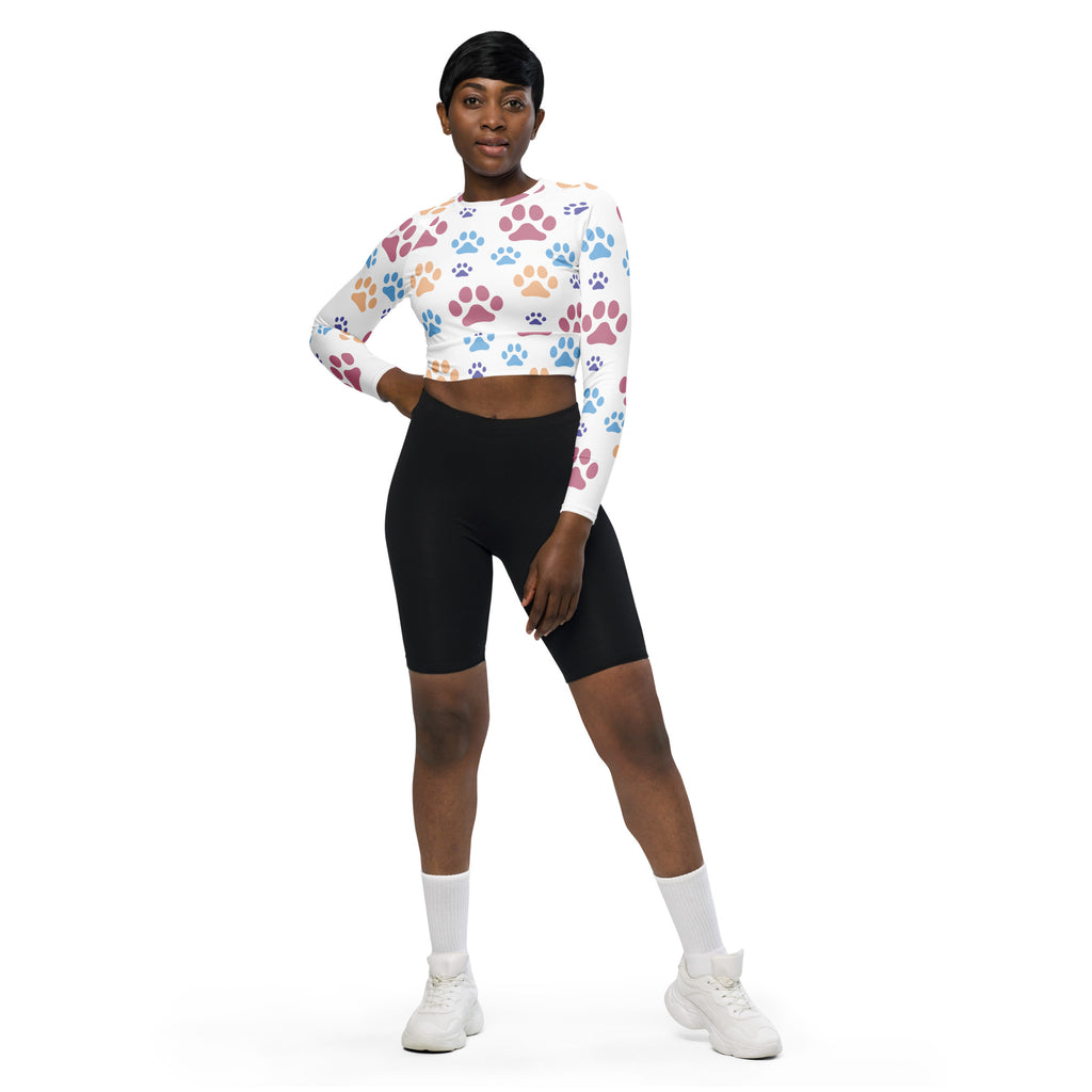 Women’s white long sleeve performance crop top with colorful pink blue and orange paw print pattern