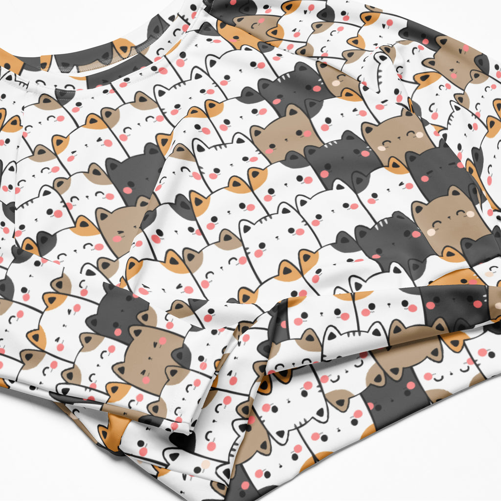 Women’s kawaii cat face long sleeve performance crop top in white with playful cartoon cat pattern in black brown and orange