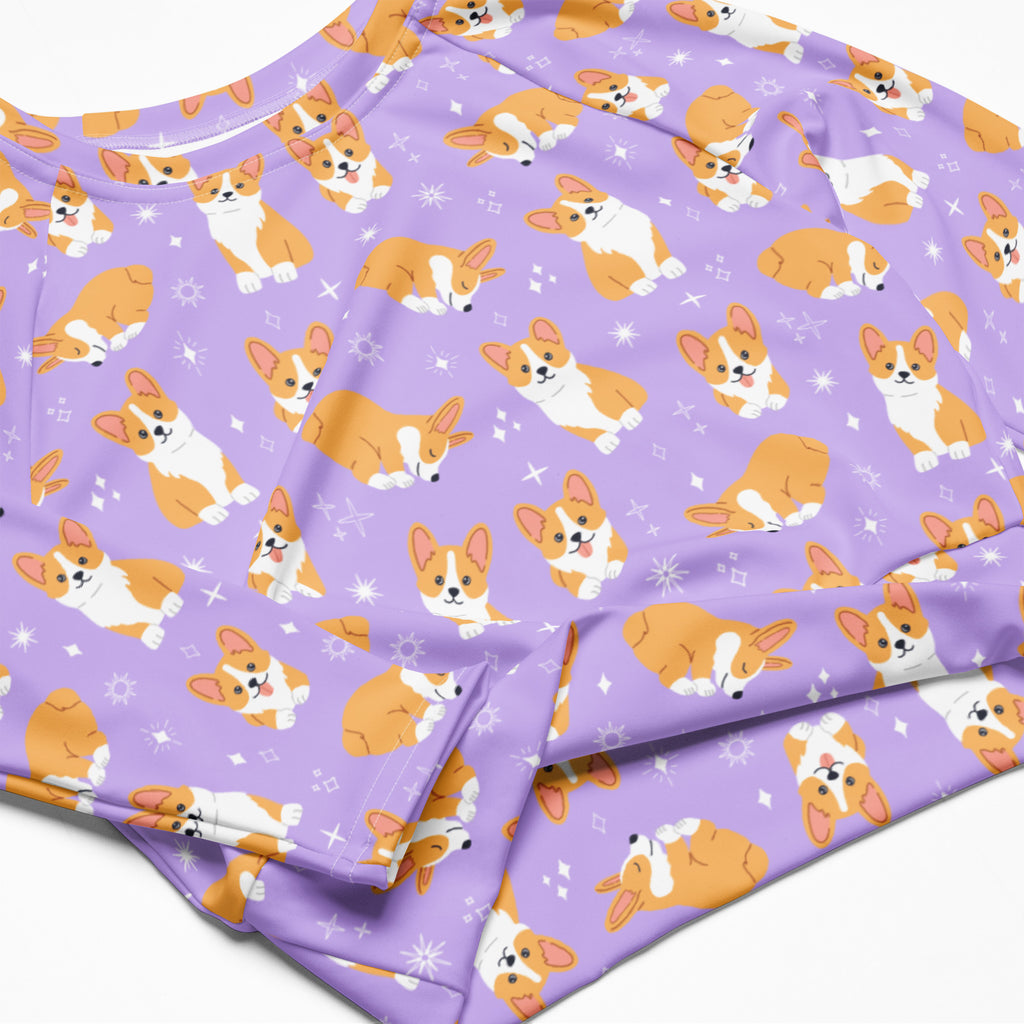 Women’s purple long sleeve performance crop top with orange and white corgi dog pattern and starburst accents