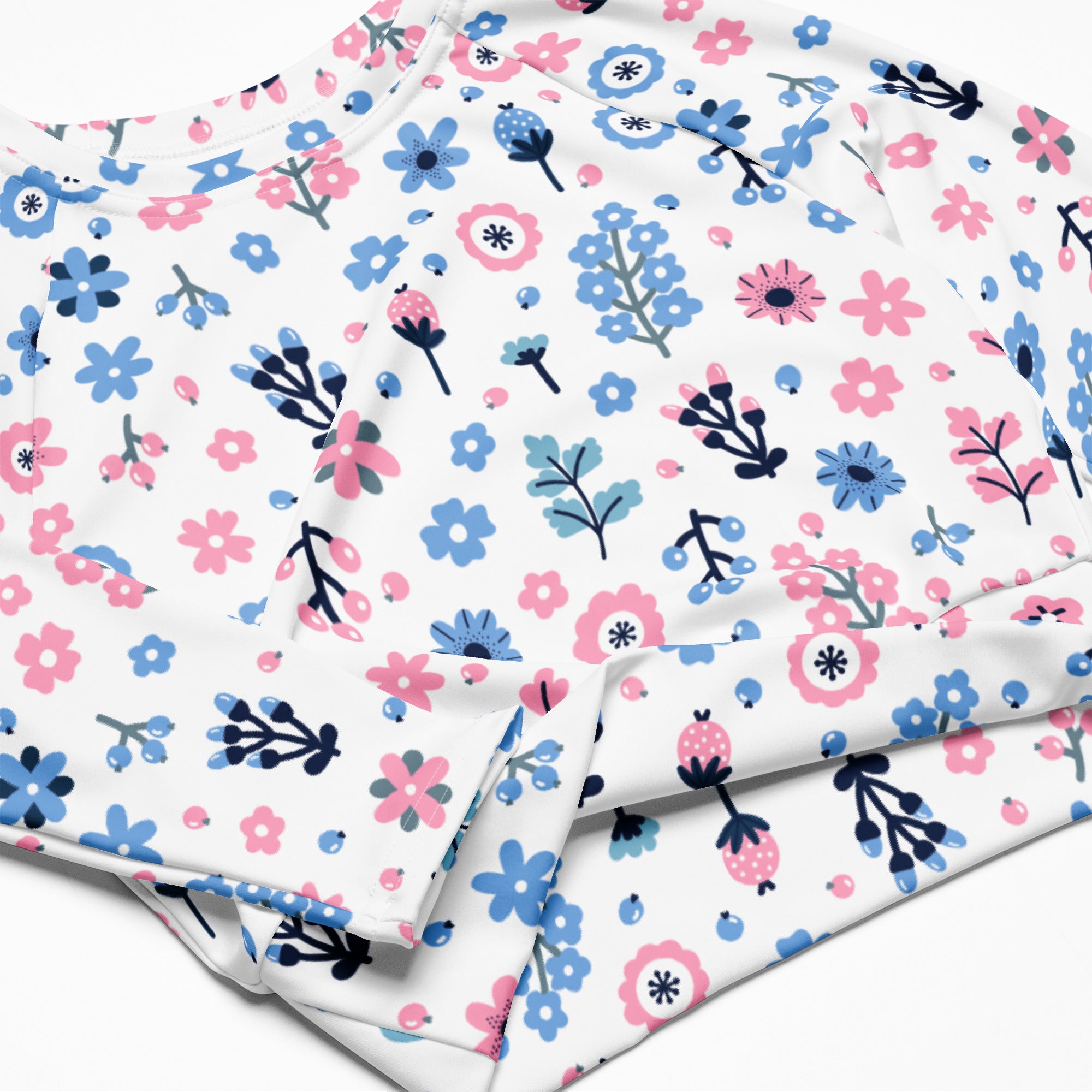 Women’s pastel floral print long sleeve performance crop top soft white fabric with pink blue flowers and green stems