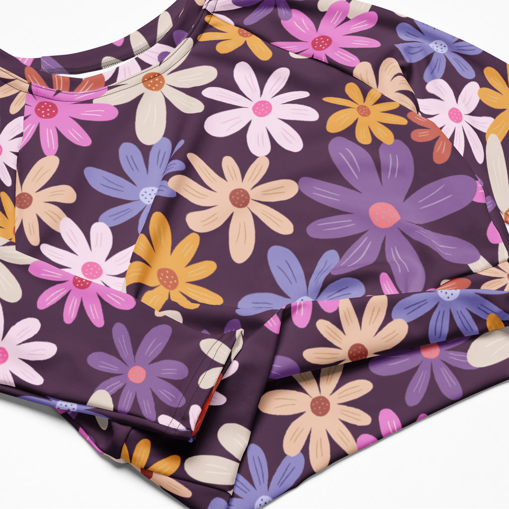 Women’s purple floral long sleeve performance crop top with vibrant cartoon daisies in pink yellow blue and cream