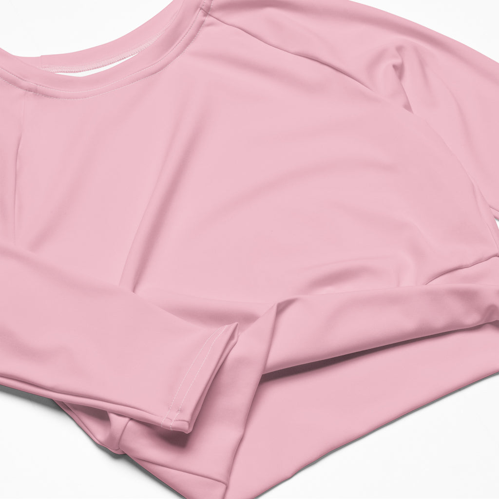 Women’s light pink long sleeve performance crop top with rounded neckline and smooth lightweight fabric