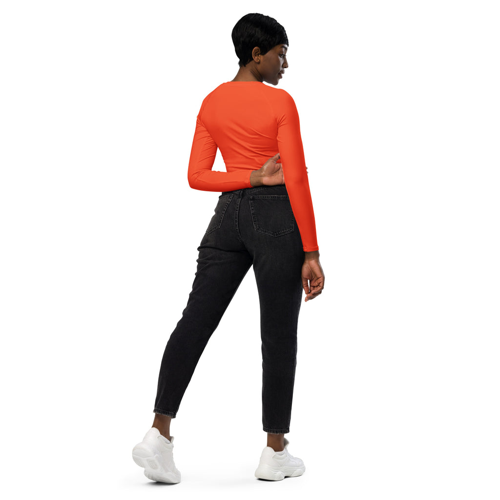 A vibrant orange long sleeve performance crop top with a fitted silhouette for women