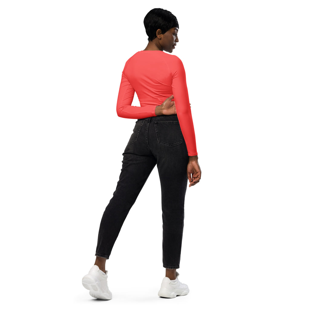 Women’s coral long sleeve performance crop top with a round neckline and fitted silhouette for active wear