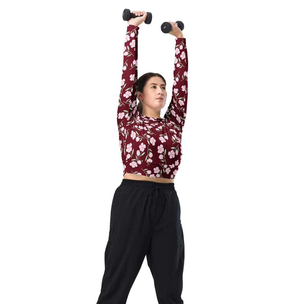 Women’s burgundy floral long sleeve performance crop top with pink blossoms and green stems design