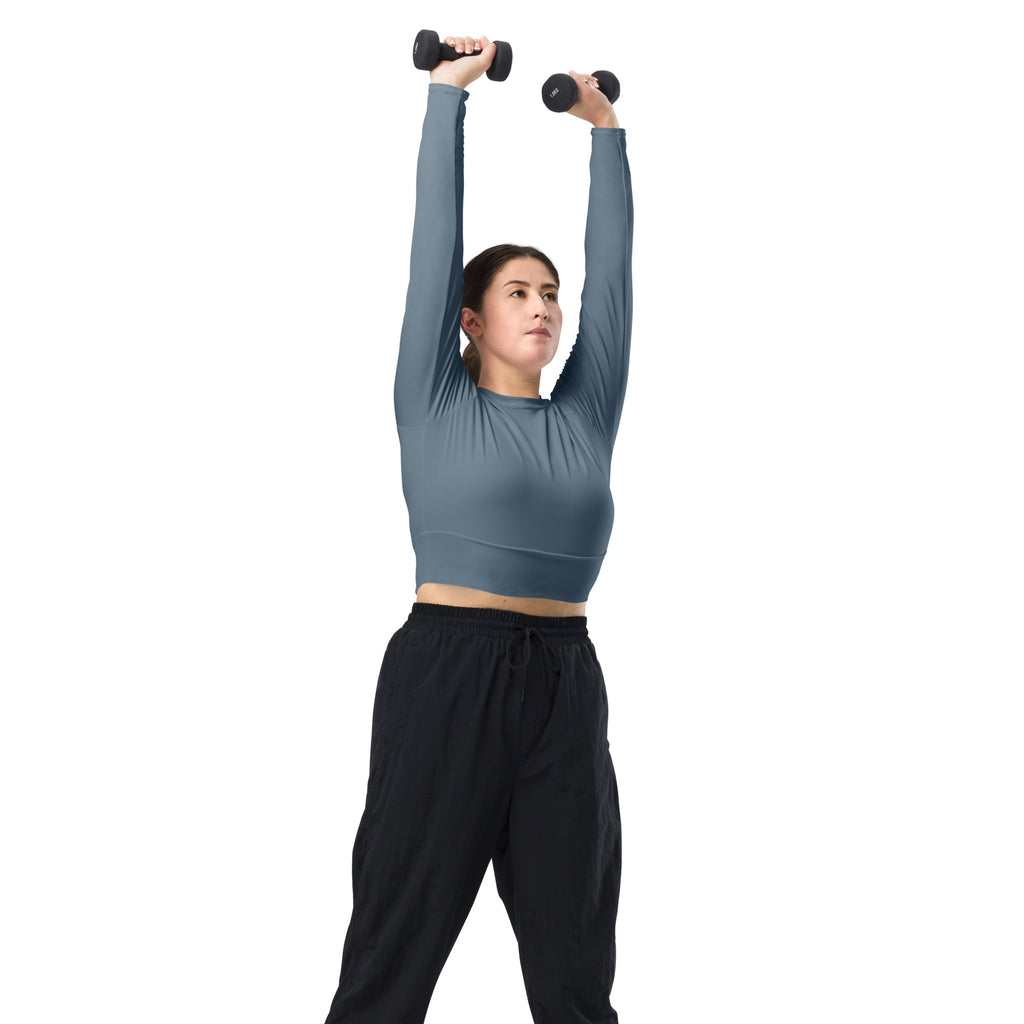 Black dumbbells with textured grip surfaces shown alongside a women’s slate blue long sleeve performance crop top