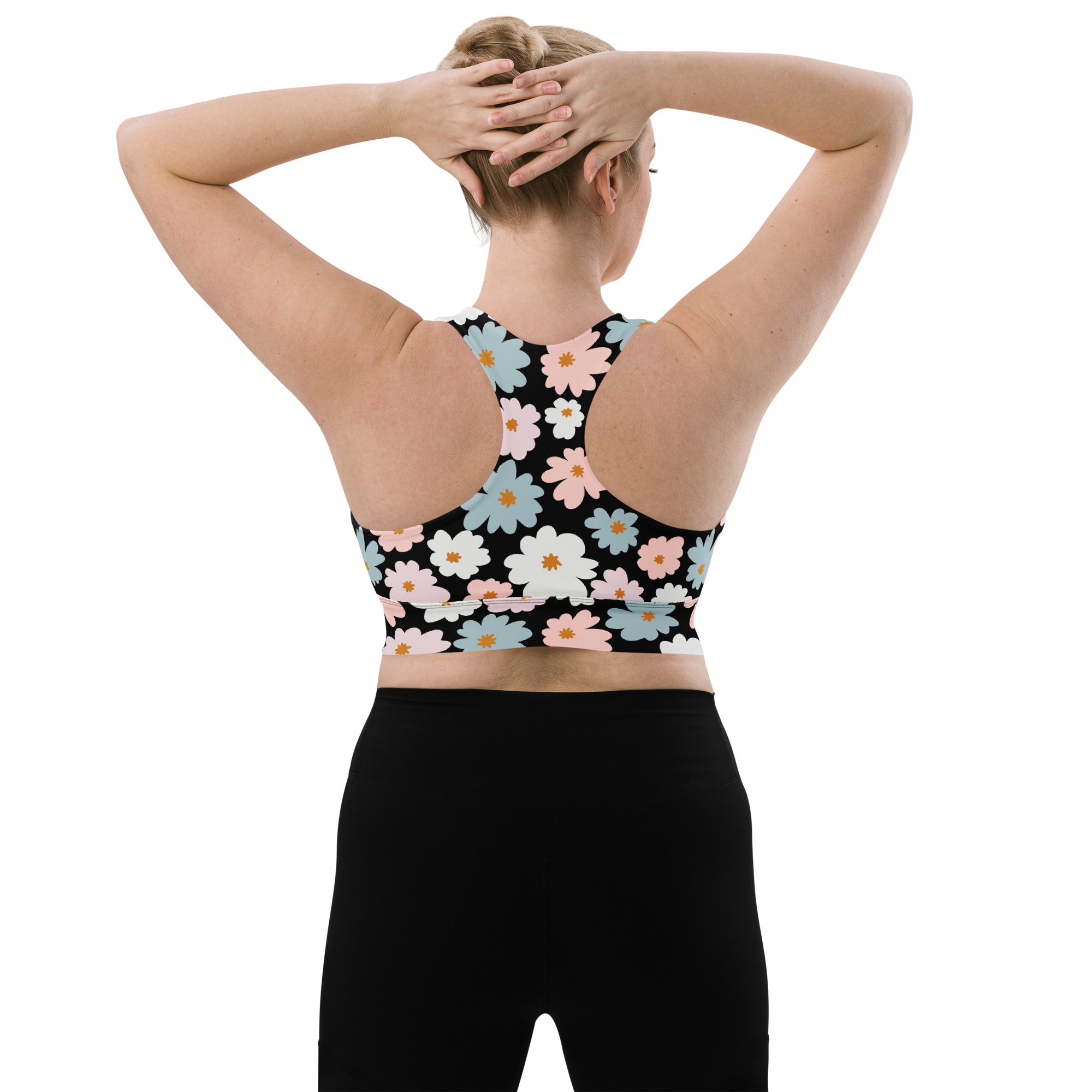 Women’s black recycled longline sports bra with vibrant pink white and blue daisy floral pattern high intensity support