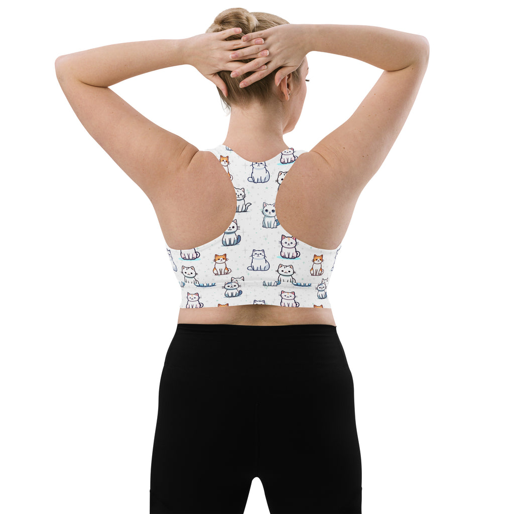 White longline sports bra with playful multicolor cartoon cats, buttery soft recycled fabric, racerback design, high support