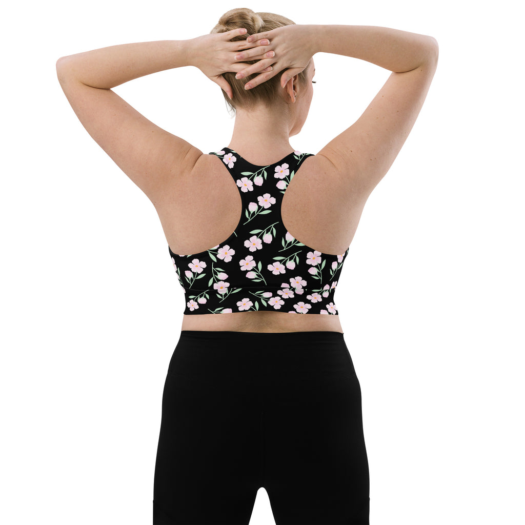 Women’s black recycled longline sports bra with delicate pink floral pattern racerback design and high intensity support