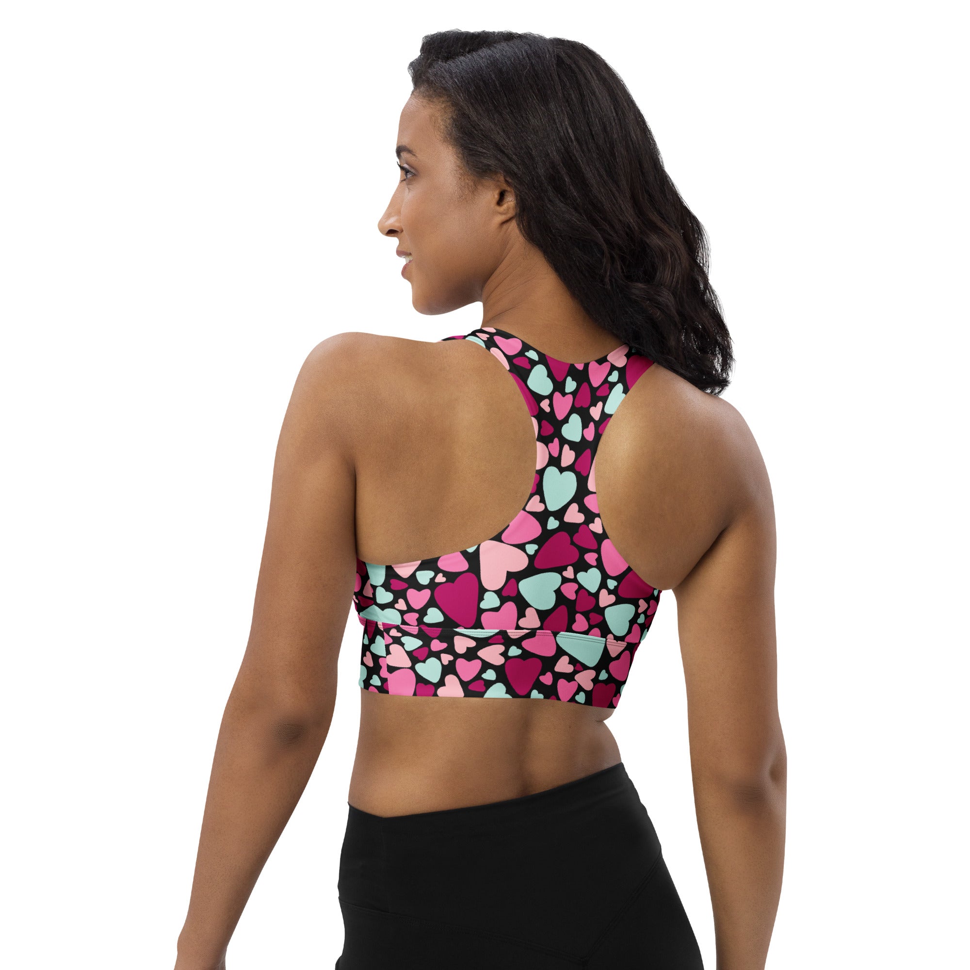 A vibrant women’s Valentine’s Day recycled longline sports bra with multicolor heart pattern and high intensity support