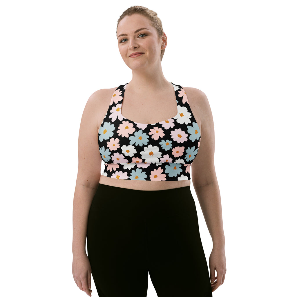 A black women’s retro floral longline sports bra with pastel daisy pattern, buttery soft recycled fabric, high intensity support