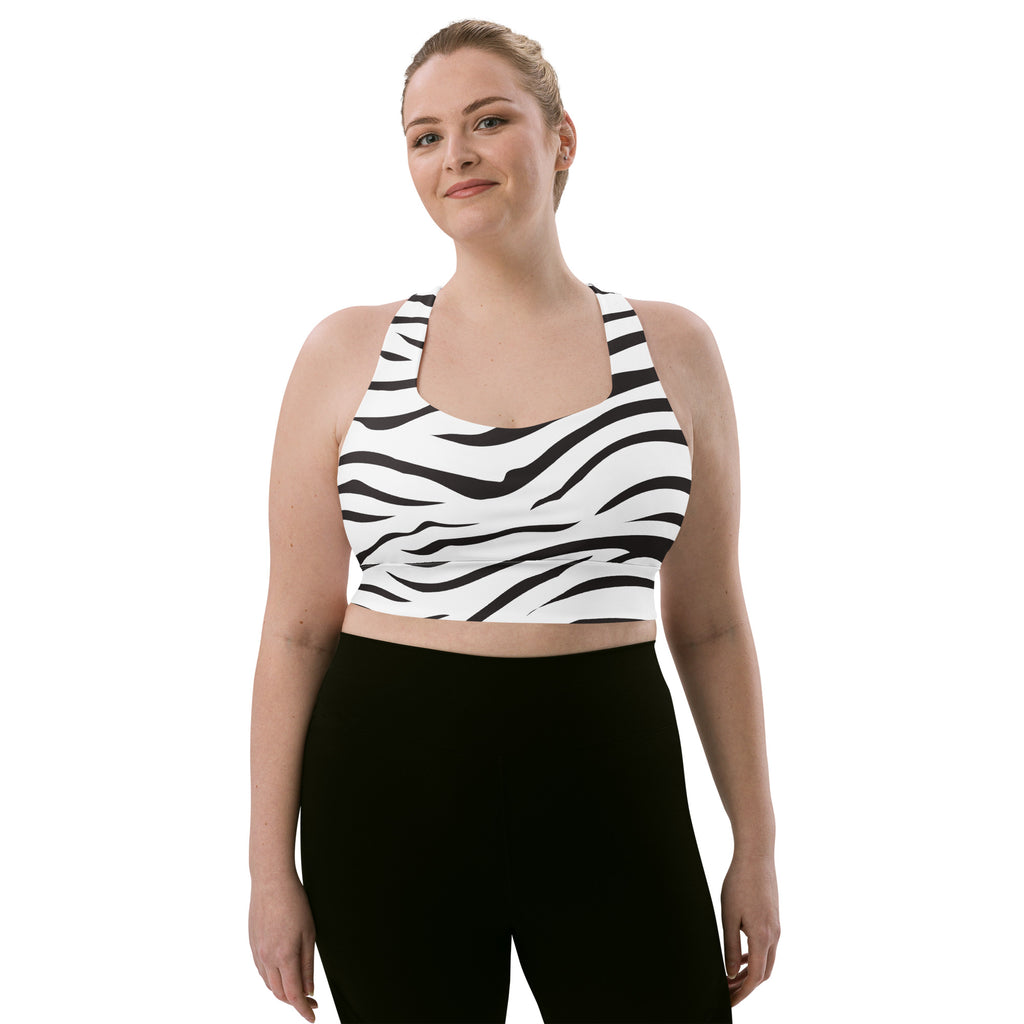 A plus-size woman wears a white and black zebra print buttery soft recycled sports bra with high intensity support