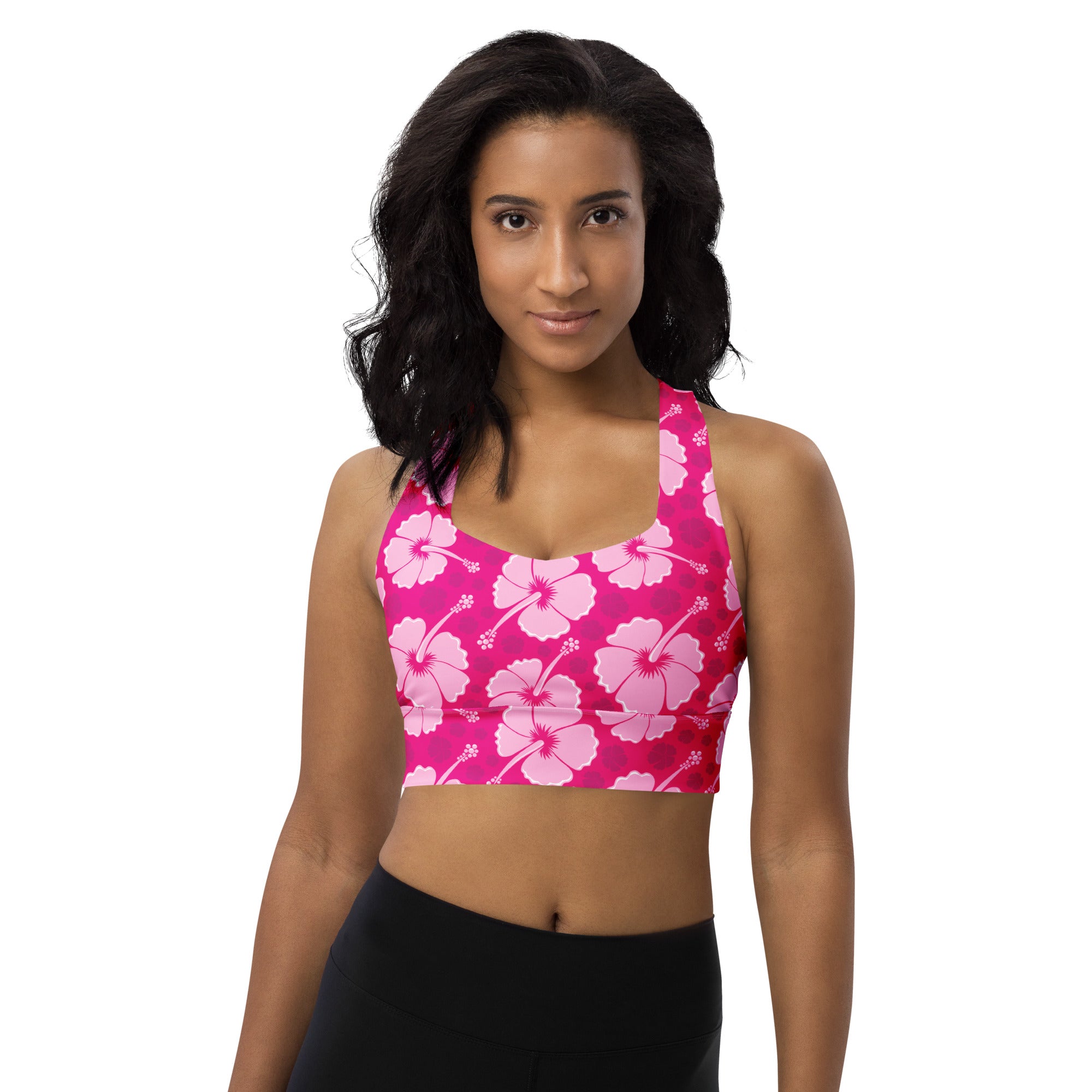 A vibrant pink recycled longline sports bra with light pink hibiscus flowers offering high intensity support