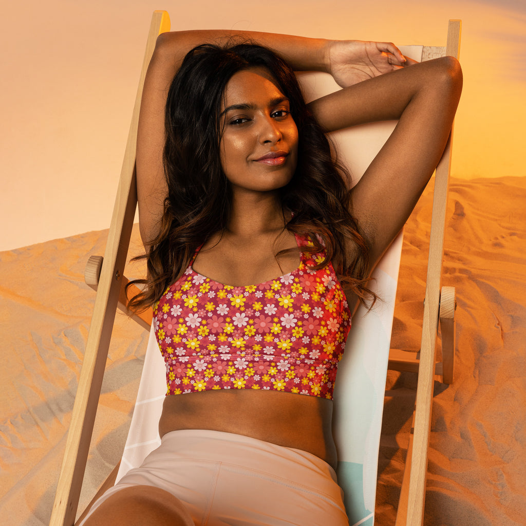 A vibrant pink and yellow floral longline sports bra with buttery soft recycled fabric and high intensity support
