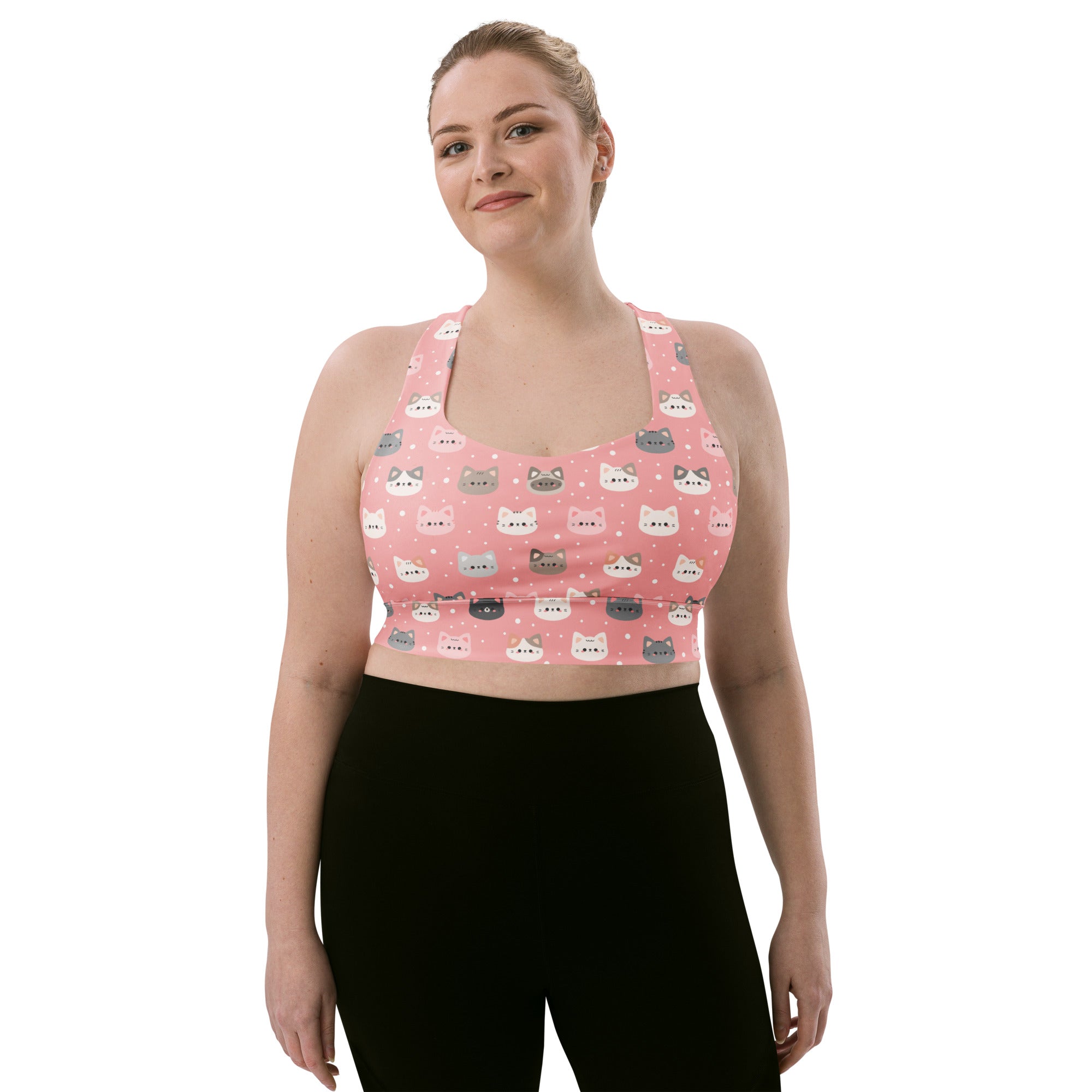 Women’s cute pink longline sports bra with playful cartoon cat faces pattern, buttery soft recycled fabric, high support