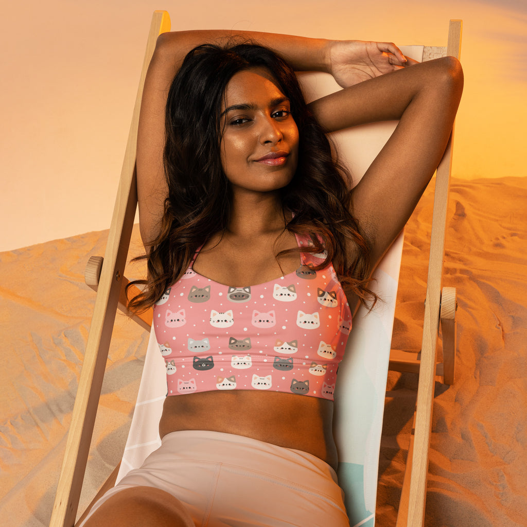 Pink cropped sports bra with playful colorful cartoon cat pattern made from buttery soft recycled fabric for high intensity support