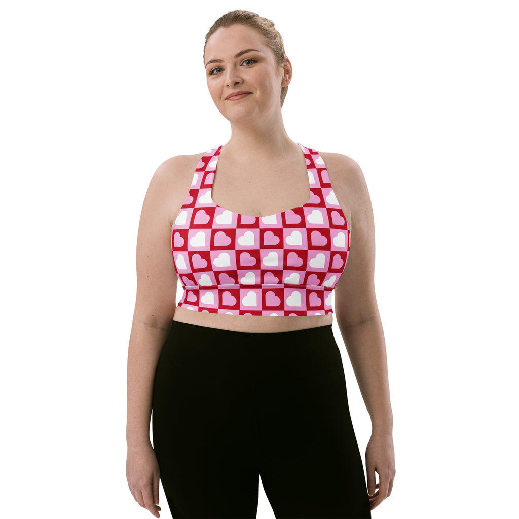Women’s longline sports bra with pink and white heart checker print made from buttery soft recycled fabric