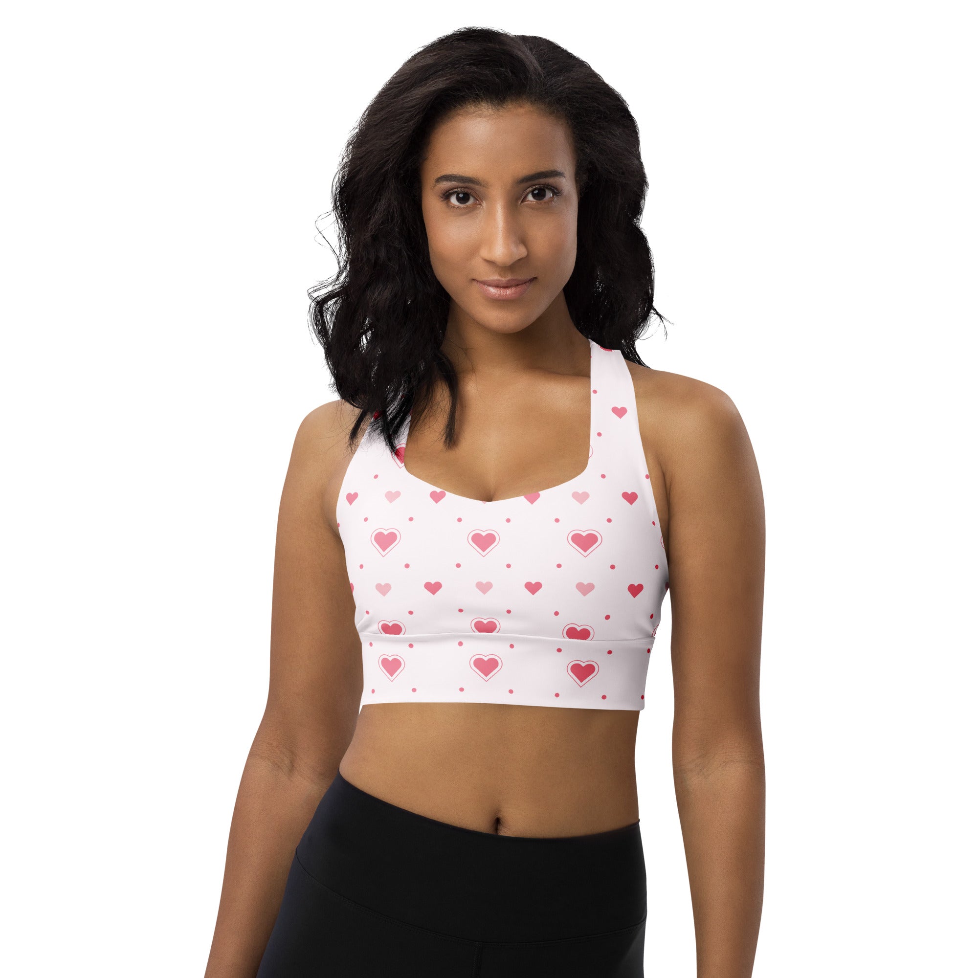 White buttery soft recycled longline sports bra with pink heart and dot pattern for high intensity support
