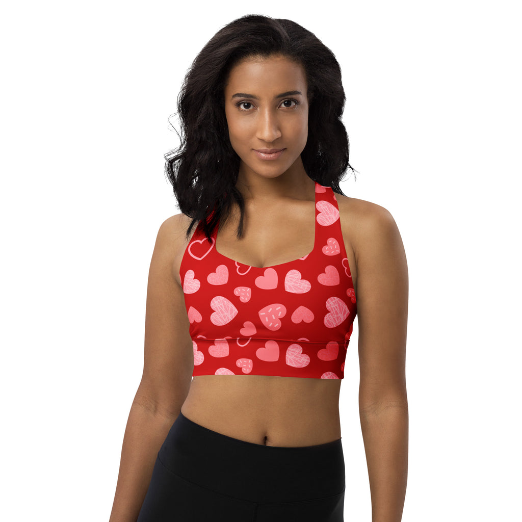 Women’s red longline sports bra with pink heart pattern made from buttery soft recycled fabric for high intensity support