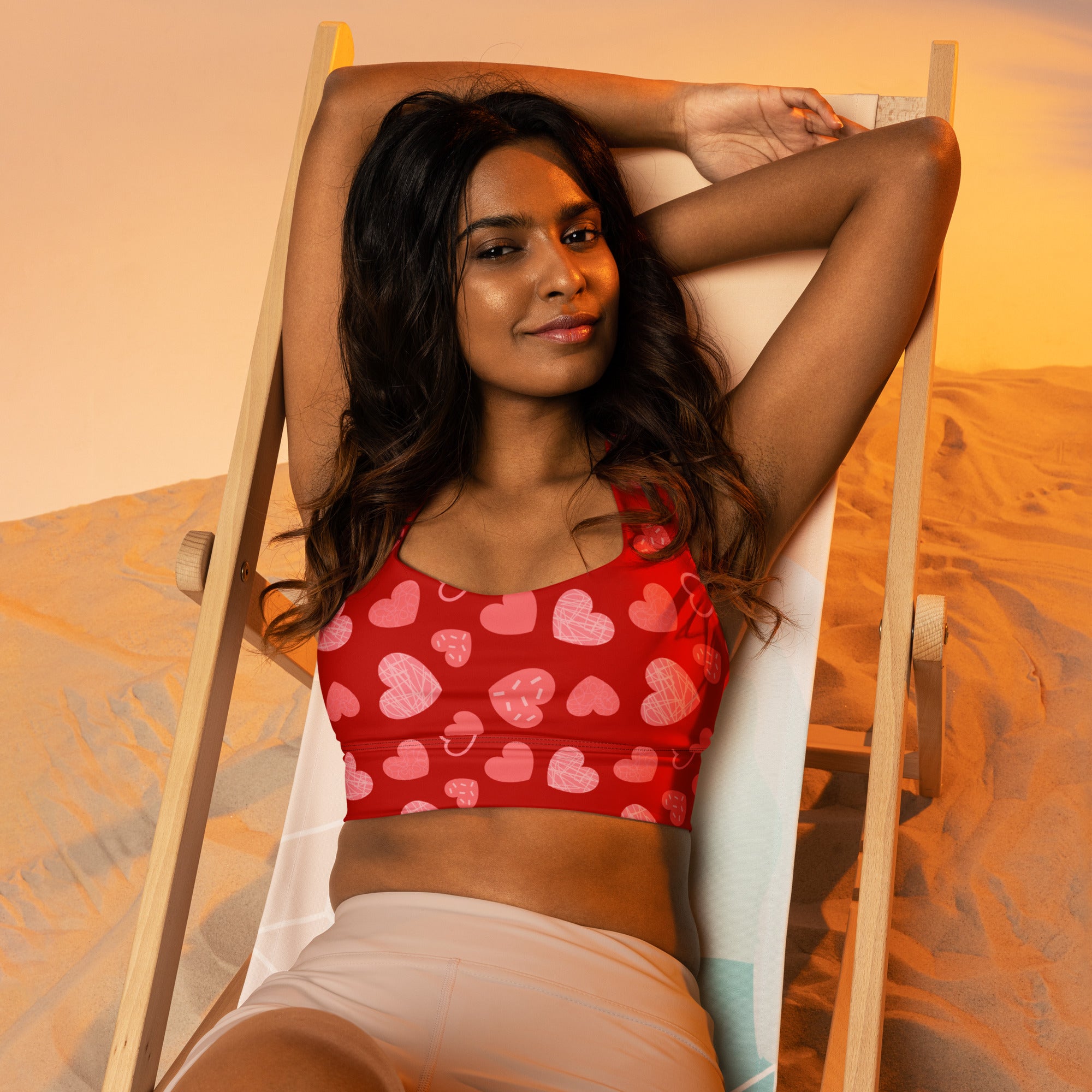 Women’s red longline sports bra with pink and white heart pattern on buttery soft recycled stretchy fabric