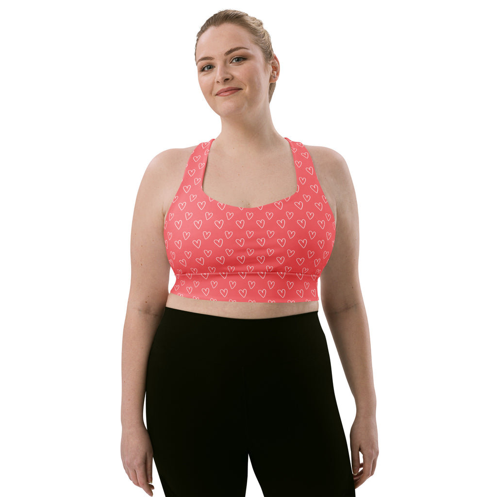 Pink longline sports bra with white heart pattern made from buttery soft recycled fabric for high intensity support