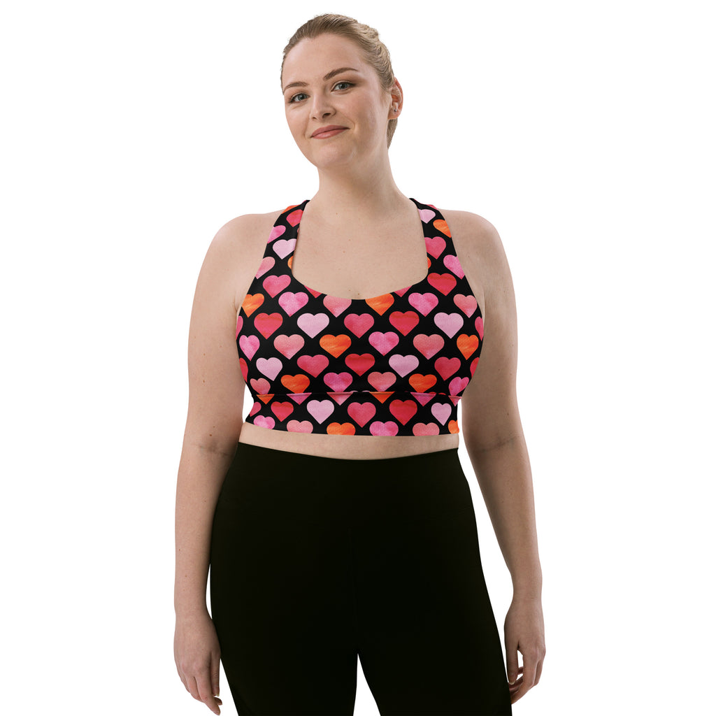 Black sports bra with vibrant pink and orange heart pattern made from buttery soft recycled fabric for high intensity support