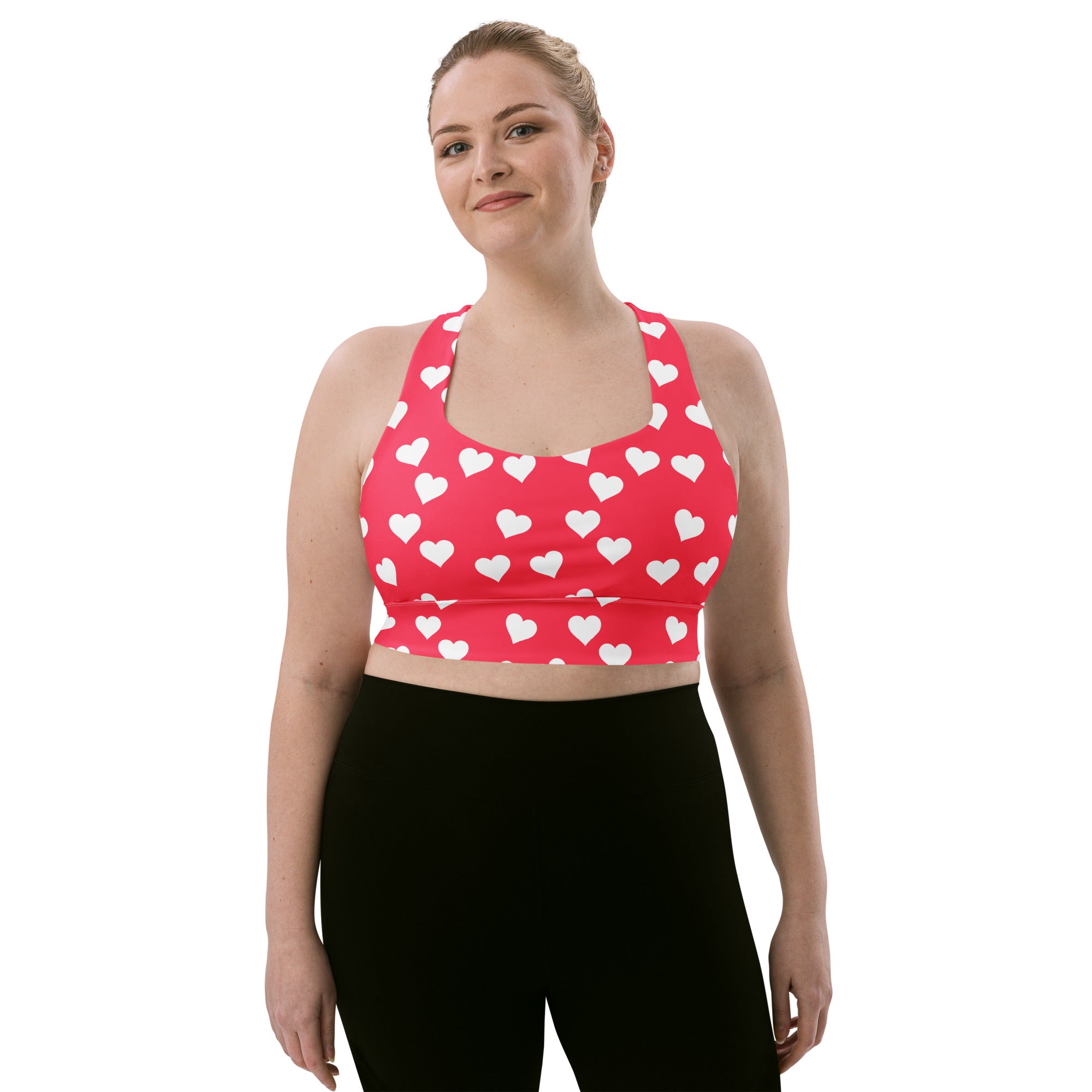 Women’s pink sports bra with white heart pattern buttery soft recycled fabric high intensity support and upf 50+