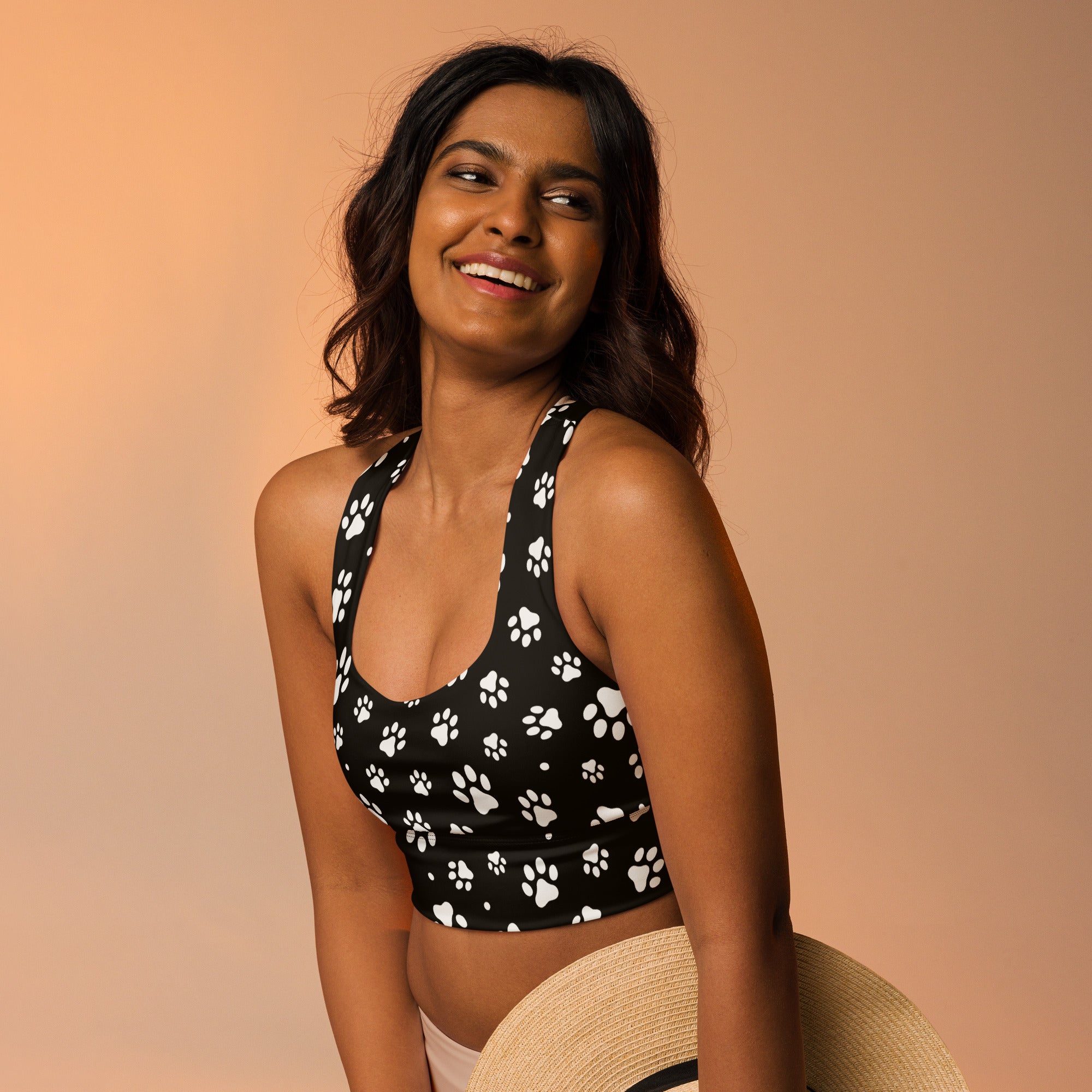 Women’s black sports bra with white paw print pattern made from buttery soft recycled fabric for high intensity support