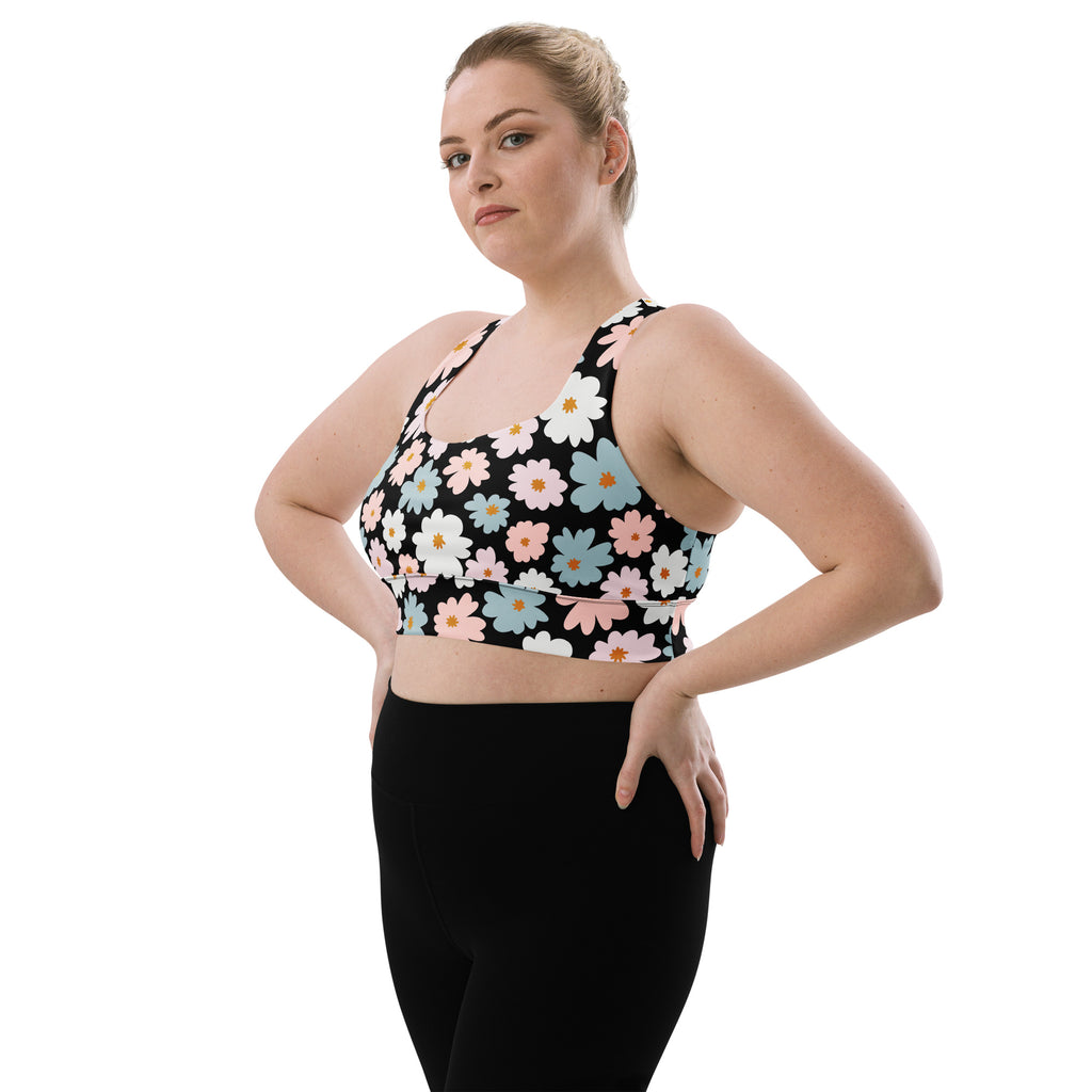 Black longline sports bra with vibrant white pink and blue daisy floral pattern buttery soft recycled fabric