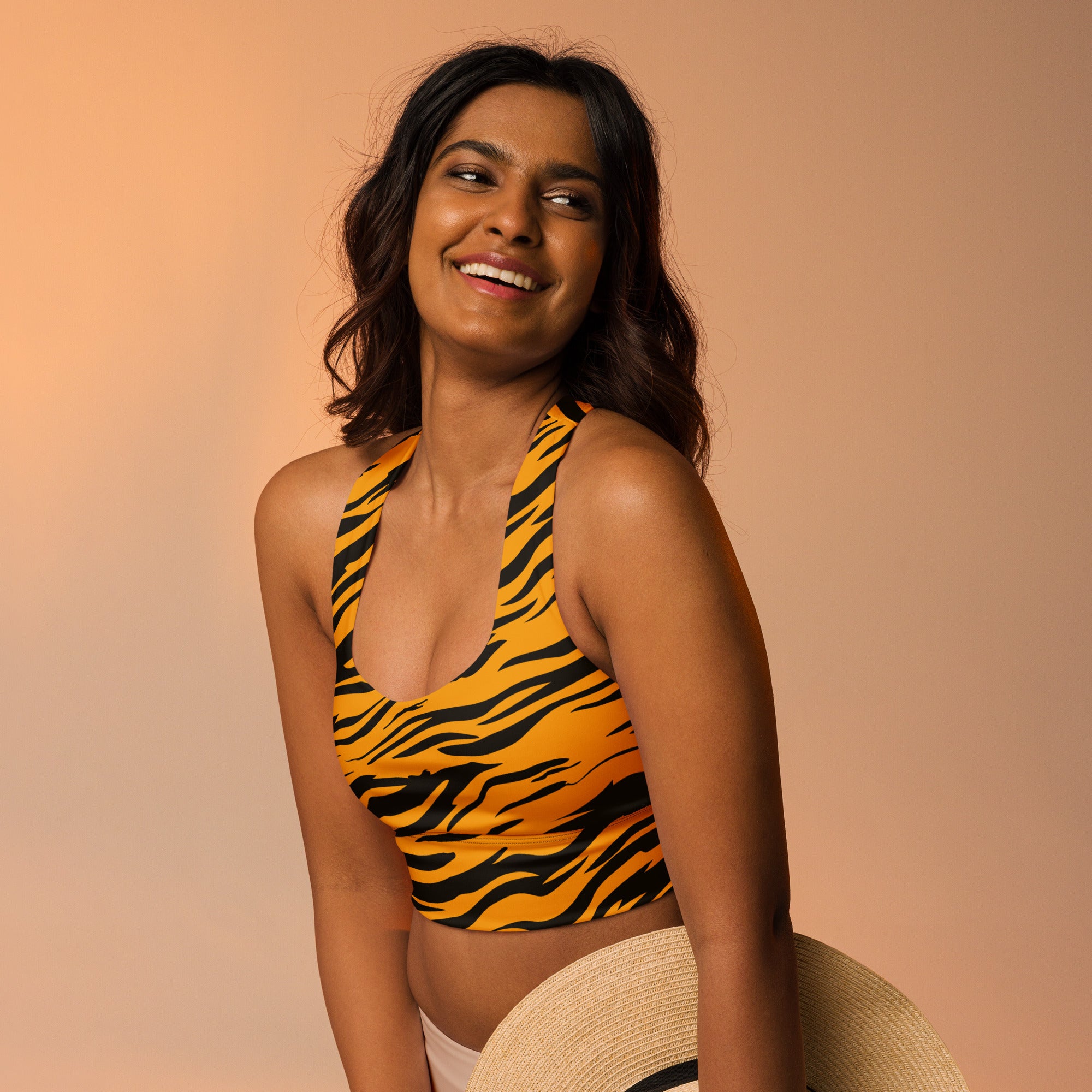 A vibrant yellow and black tiger print buttery soft recycled longline sports bra with high intensity support