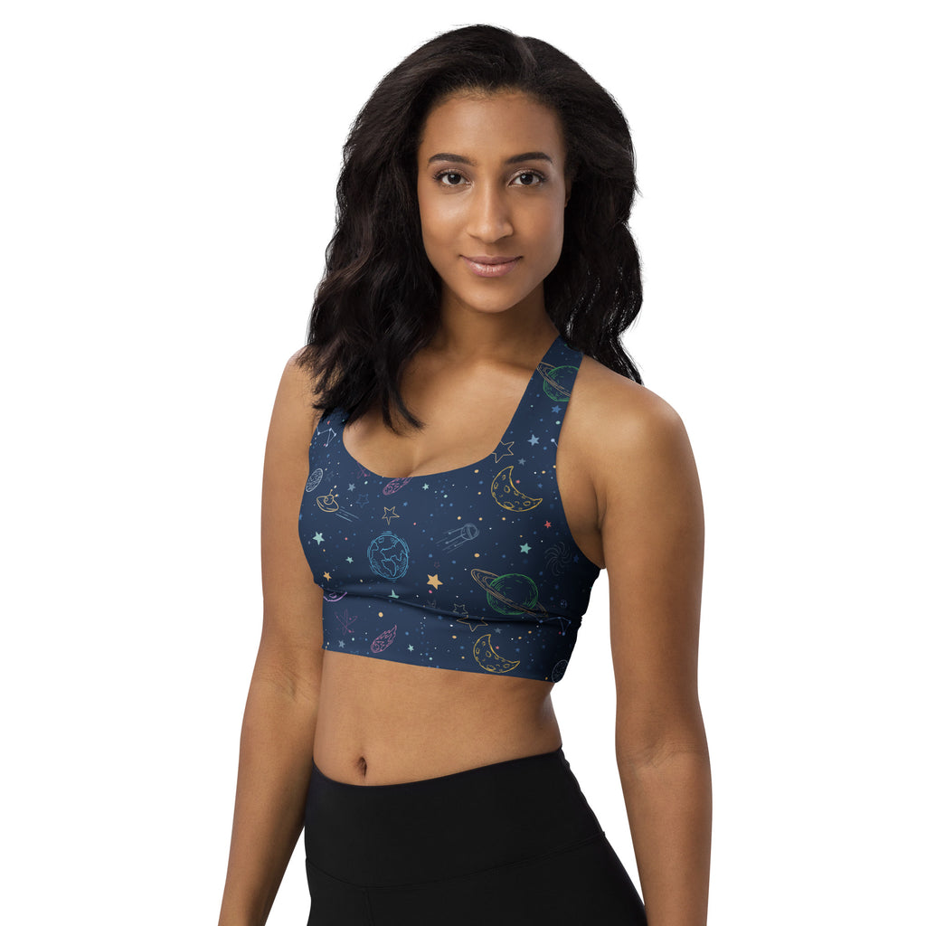 A navy blue sports bra with a colorful galaxy design featuring glowing planets and stars in buttery soft recycled fabric