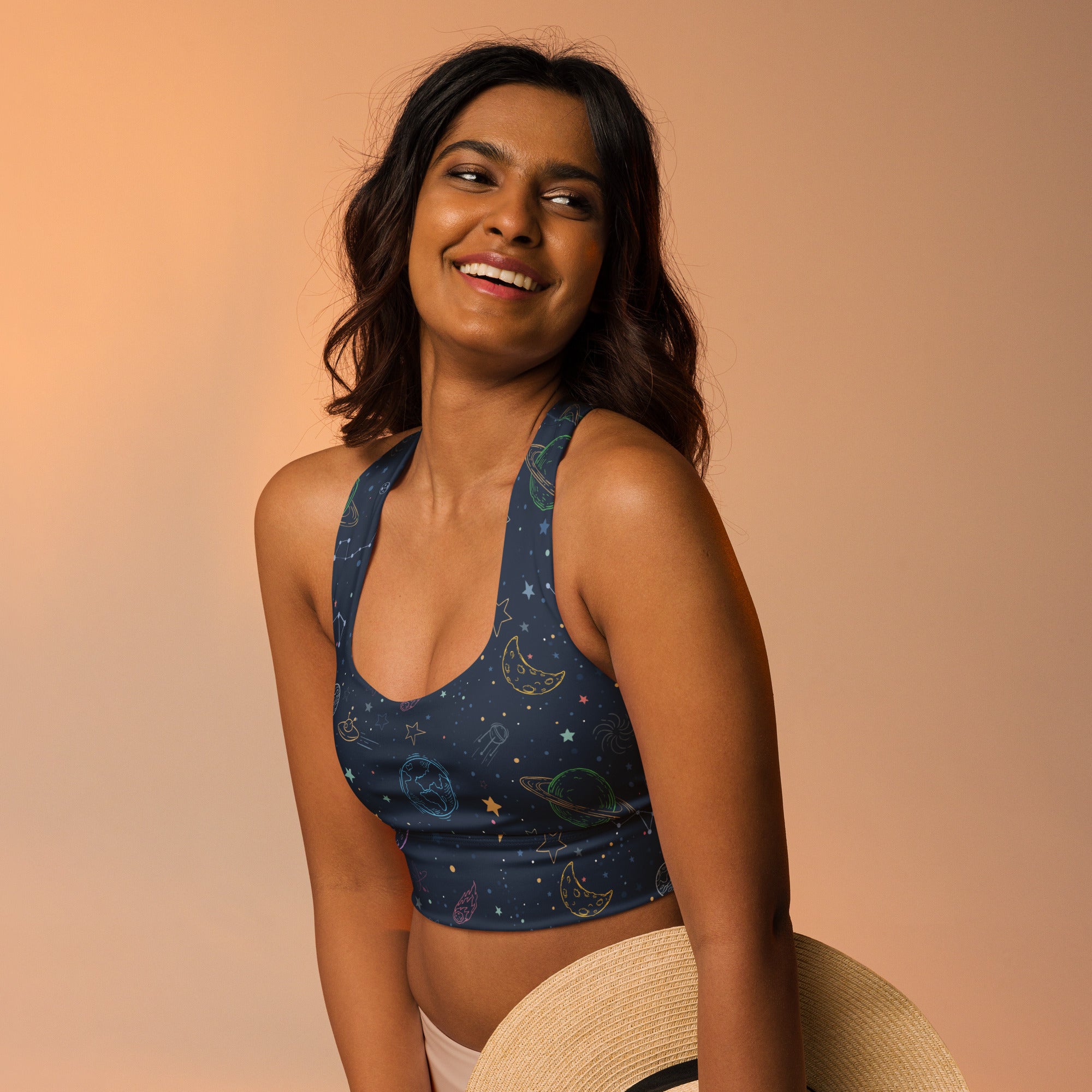 A navy blue recycled crop top sports bra with halter neckline and pastel galaxy print for high intensity support