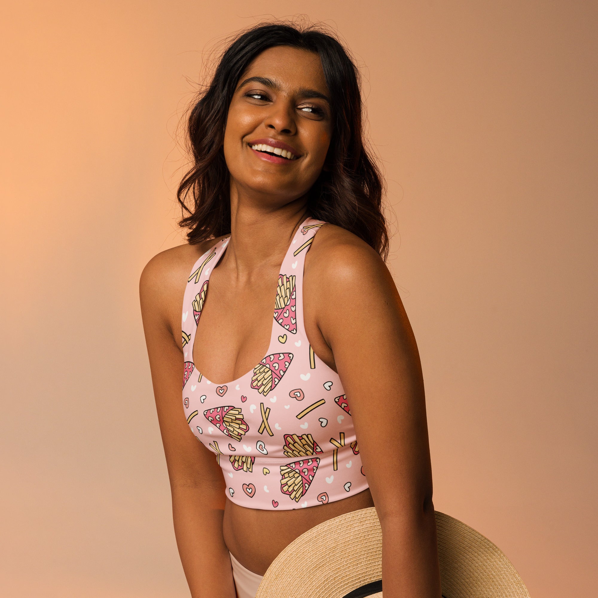 Women’s pink buttery soft recycled longline sports bra with playful pizza fries and hearts pattern for high intensity support