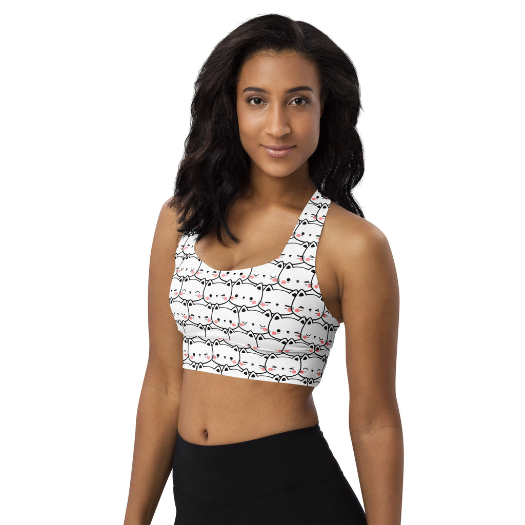 White longline sports bra with playful cartoon cat faces, buttery soft recycled fabric, high intensity support, and UPF 50+
