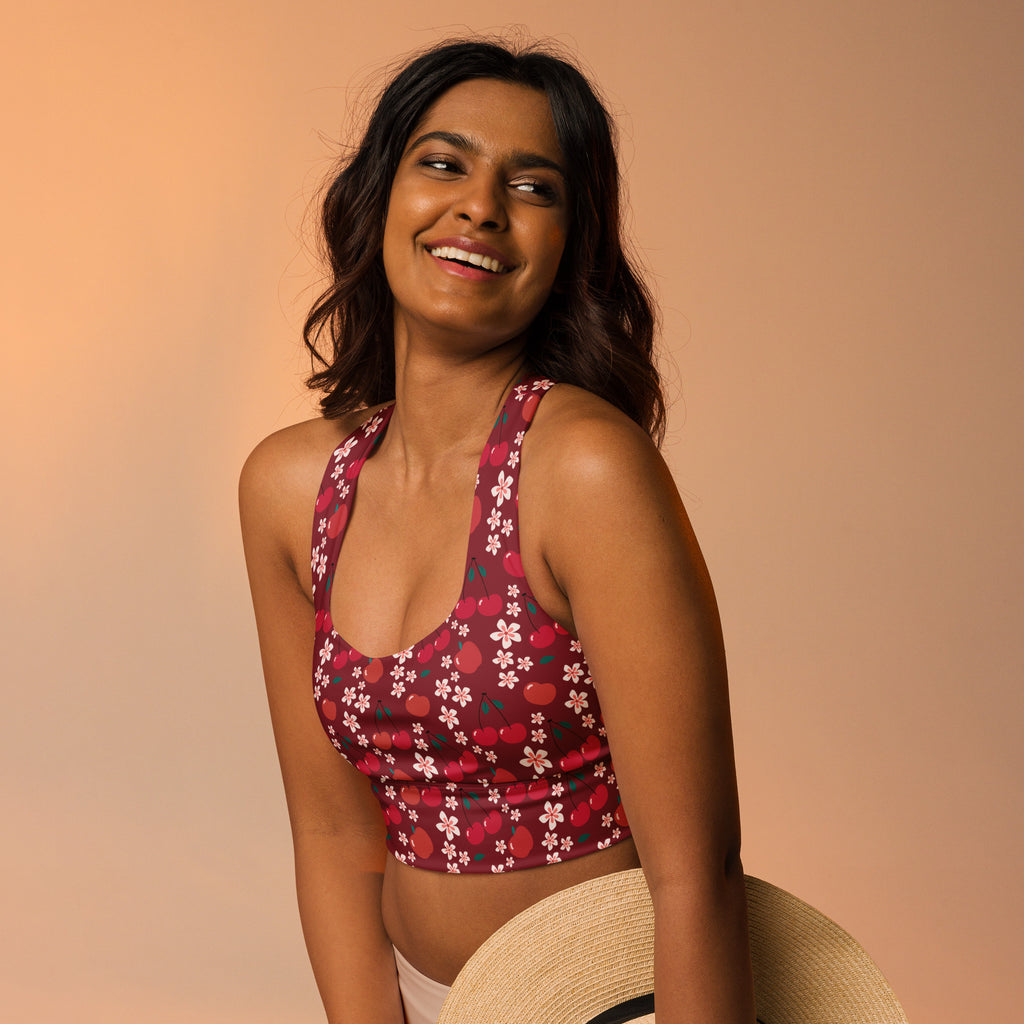 A maroon longline sports bra with floral cherry pattern featuring thin straps and halter neckline for high intensity support