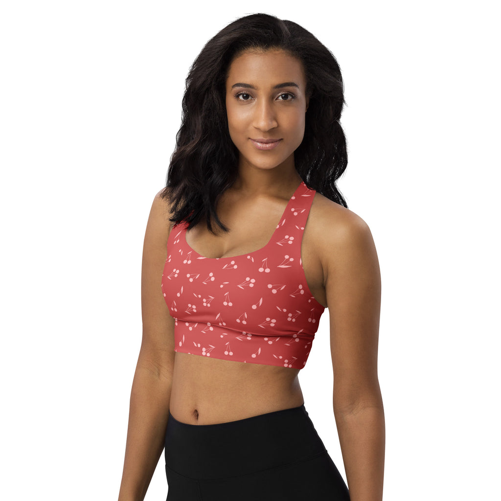 A coral sports bra with cherry and musical note pattern buttery soft recycled fabric high intensity support