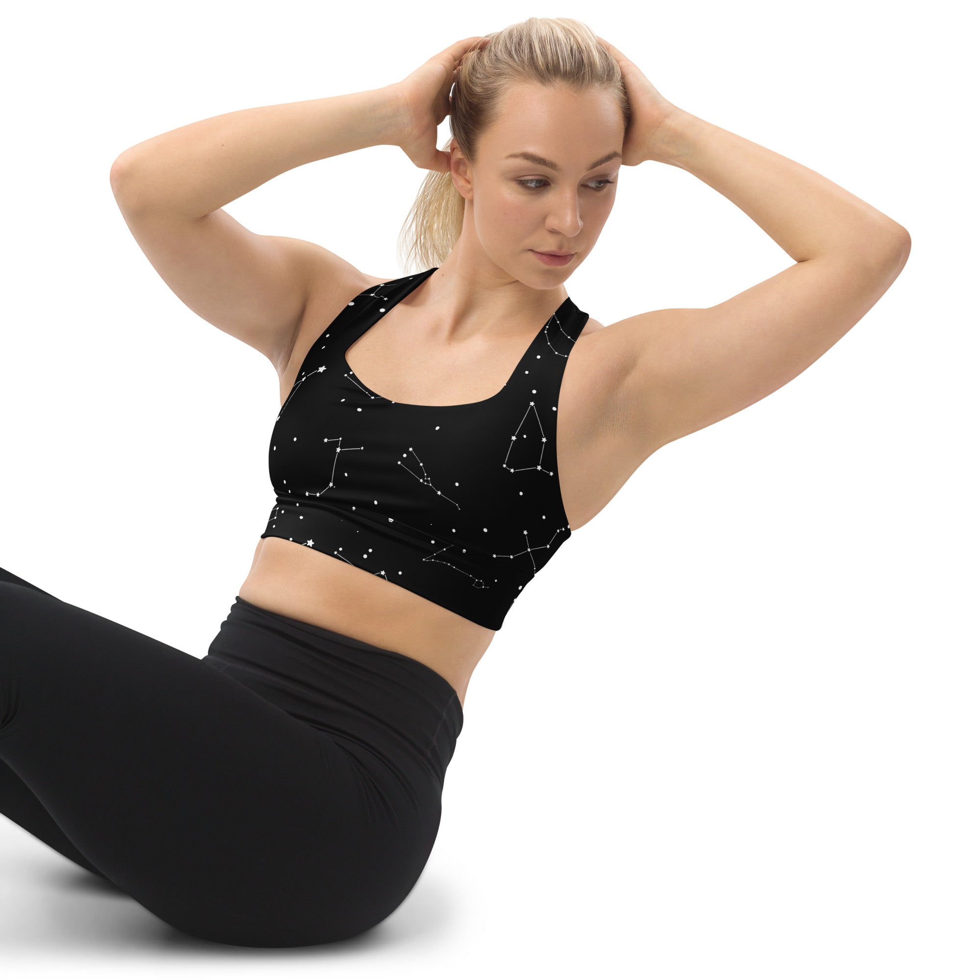 Women’s black longline sports bra with white constellation pattern made from buttery soft recycled fabric for high intensity support