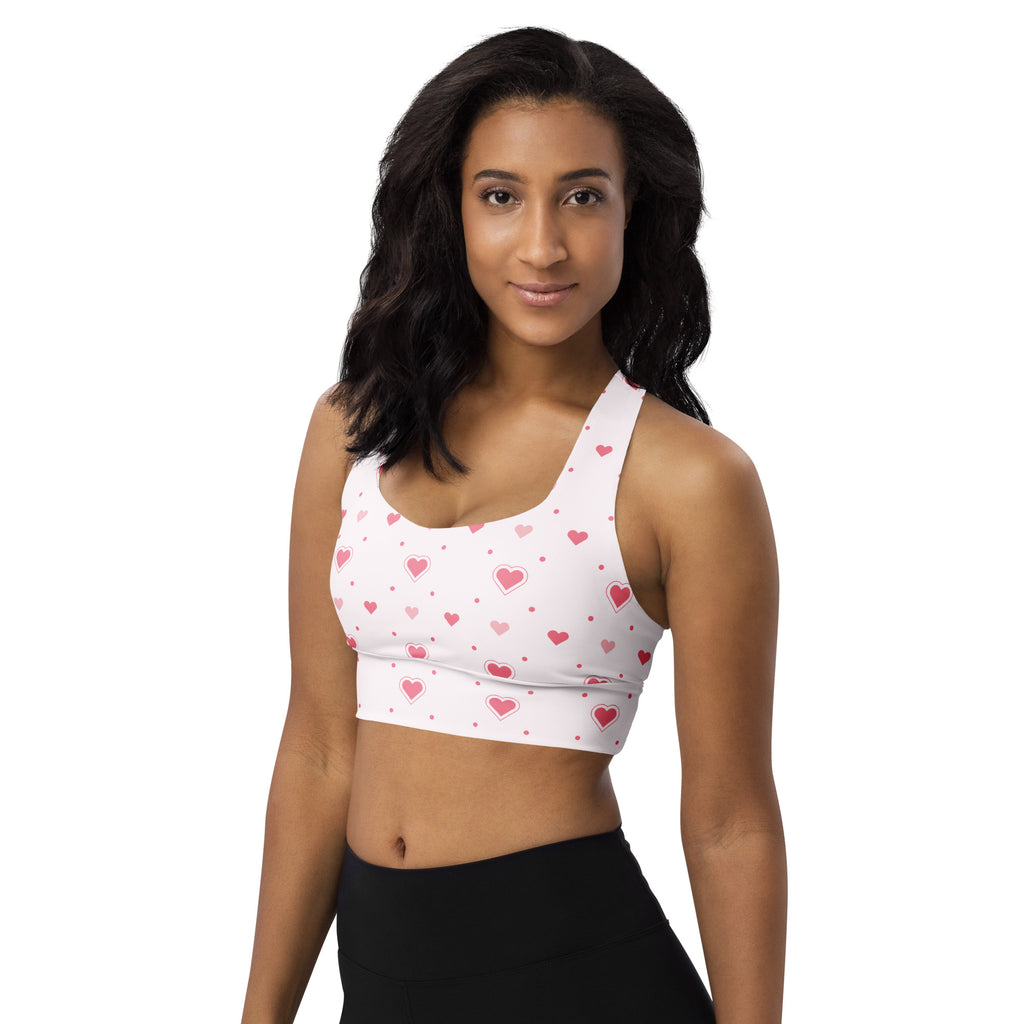 White buttery soft recycled longline sports bra with pink heart and dot pattern for high intensity support